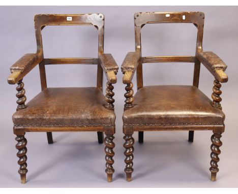 A pair of late 19th/early 20th century oak rail-back carver dining chairs each with a padded seat upholstered tan leather, &a