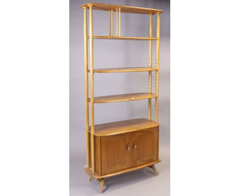 A 1950s ERCOL LIGHT ELM “GIRAFFE” TALL ROOM DIVIDER with three open shelves to the top above cupboard below enclosed by a pai