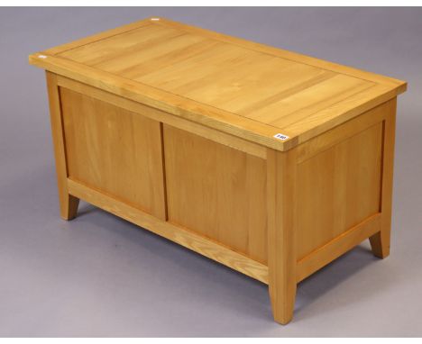 A light oak blanket box with a hinged lift-lid, &amp; with a panelled front &amp; sides, 90cm wide x 50cm high x 47cm deep. 