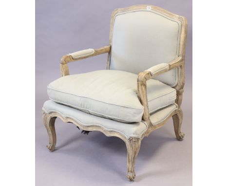 A continental-style carved beech frame armchair with a padded seat &amp; back upholstered light grey material, &amp; on slend