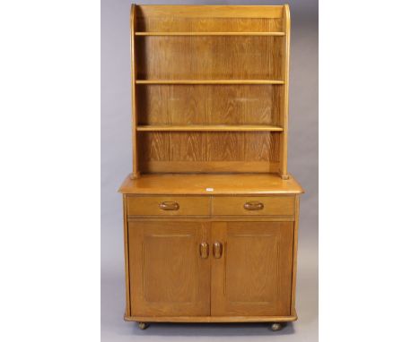 An Ercol? Light elm small dresser fitted three open shelves to the upper part, the base fitted two frieze drawers above cupbo