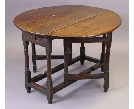 An 18th century oak circular gate-leg dining table fitted end drawer, and on turned legs &amp; turned feet with plain stretch