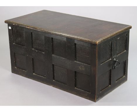 A vintage ebonised stained oak travelling trunk with a hinged lift-lid, panelled front &amp; sides, &amp; with wrought-iron s