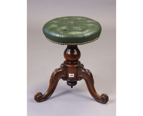 A Victorian walnut piano stool with a brass studded &amp; green leatherette revolving seat, &amp; on a vase-turned centre col