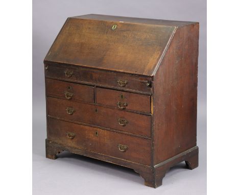 A 19th century oak bureau with a fitted interior enclosed by a fall-front above a mock-drawer &amp; two short &amp; two long 