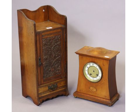 An early 20th century pipe-smoker’s cabinet with a fitted interior enclosed by a carved panel door, 21cm wide x 51cm high x 1