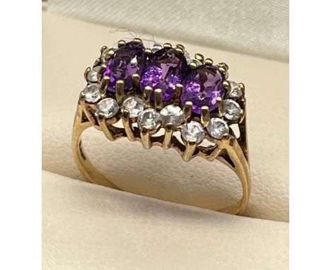 Ladies 9ct yellow gold ring; set with three oval cut amethysts surrounded by white gem stone cluster. [Ring size O 1/2] [3.18