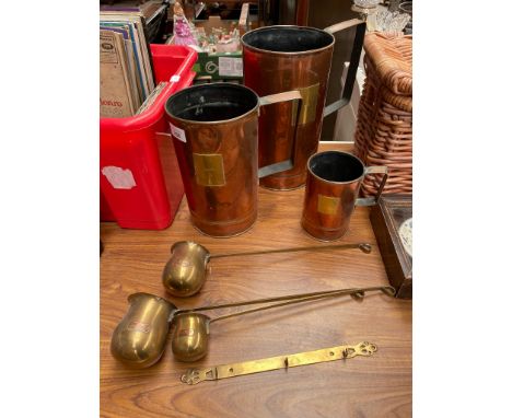 Three large copper and brass measuring jugs, Together with three Brass measures with copper labels attached 'RUM,WHISKY &amp;