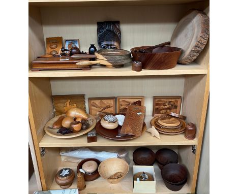 Three shelves of treen wares; Turned wooden bowls, marquetry pictures, teak Ronson lighter, Door stopper made from timber fro