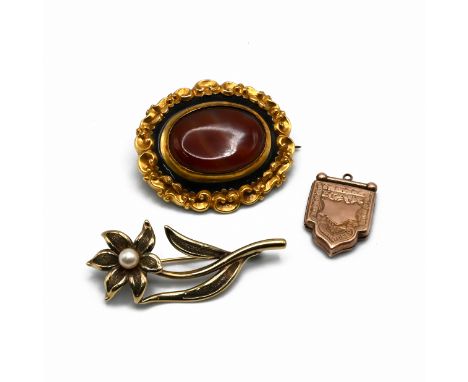 A 19th century agate set brooch, with black enamel border, C scroll and scroll border, 4.2cm long; a gilt metal locket; with 