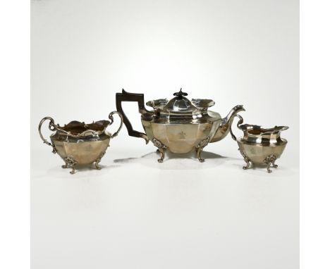 An Edwardian three piece silver tea service, Goldsmiths and Silversmiths Co Ltd, London 1903, of oval panelled outline, on fo