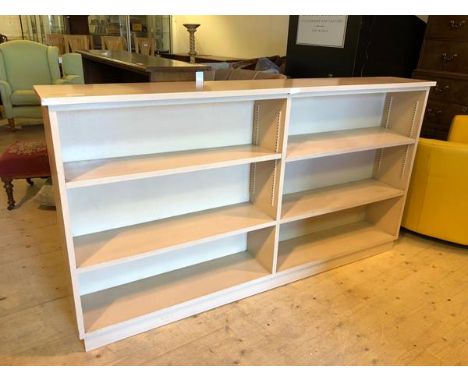 An open double bookcase the central divider flanked by single adjustable shelves over single fixed shelf on plinth base, (100