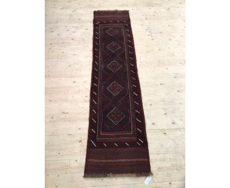 A Meshwani runner the red ground with repeating lozenge medallions and bordered, (231cm x 54cm)