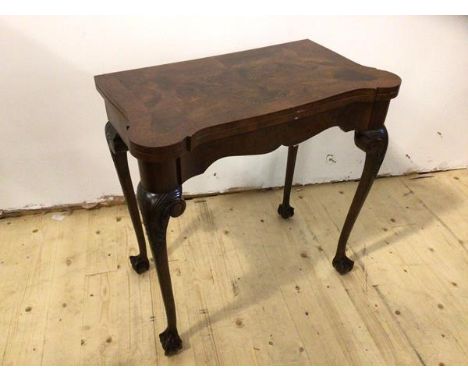 A 1930's 40's George II inspired card table the undulating swivel top opening to beize interior on cabriole supports with car