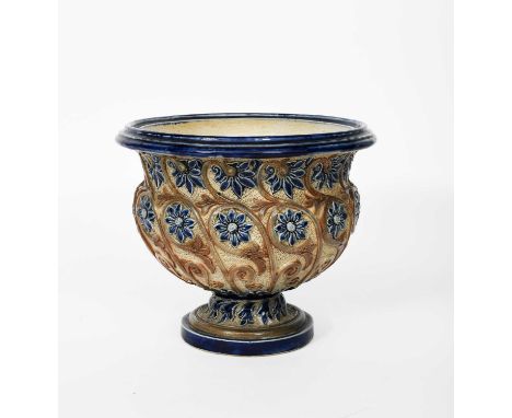 A Fulham Pottery stoneware vase designed by John Pollard Seddon, footed, swollen form, modelled in low relief with flower ste