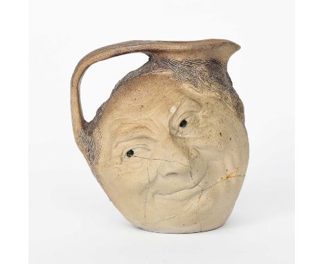 A Martin Brothers stoneware Face jug by Robert Wallace Martin, modelled in relief with a smiling face to both sides, glazed m