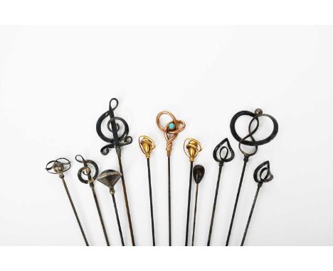 A Murrle Bennett & Co gold hat pin, scroll form with applied turquoise stone, two others smaller, a silver hat pin possibly C