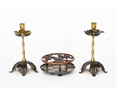A pair of WAS Benson copper and brass candlesticks, copper foliate foot supporting knopped stem, and foliate drip pan, and an