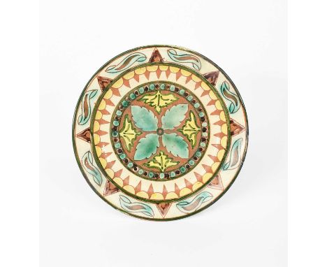 A Della Robbia Pottery plate by Annie Jones and William Warwick, painted with radiating leaf panels, inside geometric bands, 