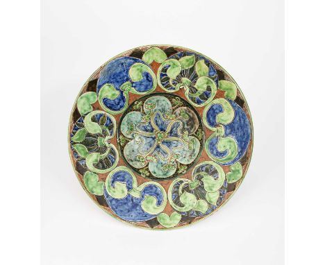 An Art Nouveau Della Robbia Pottery charger by Ruth Bare, dated 1900, incised and painted with stylised flowers on sinuous to