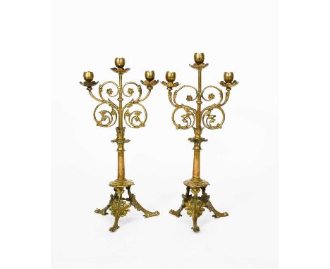 A pair of gilt bronze candlesticks the design attributed to Eugène Emmanuel Viollet Le Duc, for Poussielgue-Rusand, tripod fo