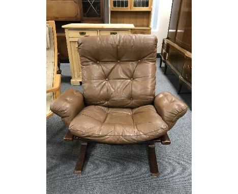 A mid 20th century brown button leather and stained beech armchair 