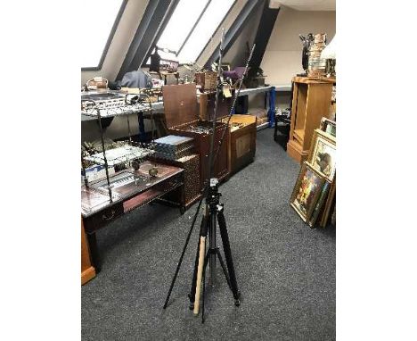 A camera tripod together with a three piece carbon fishing rod with extensions 