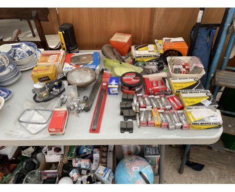 A COLLECTION OF VINTAGE AUTOMOBILE PARTS TO INCLUDE SPARK PLUGS, BRAKE PADS, ETC 