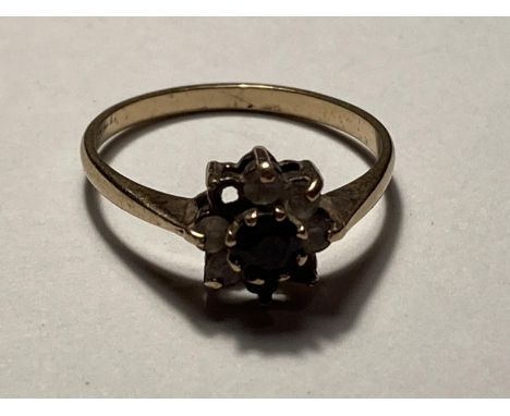 A 9 CARAT YELLOW GOLD RING WITH CENTRE GARNET AND FIVE SURROUNDING (TWO MISSING SHOULD HAVE SEVEN) CLEAR STONES SIZE Q GROSS 