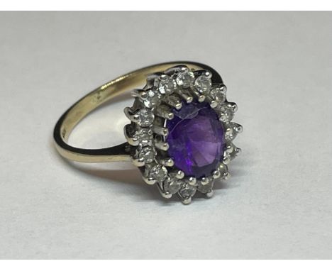A 9 CARAT GOLD RING WITH A LARGE CENTRE AMETHYST SURROUNDED BY SIXTEEN CUBIC ZIRCONIA STONES SIZE L 