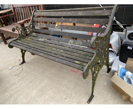 A VINTAGE WOODEN SLATTED GARDEN BENCH WITH DECORATIVE CAST BENCH ENDS 