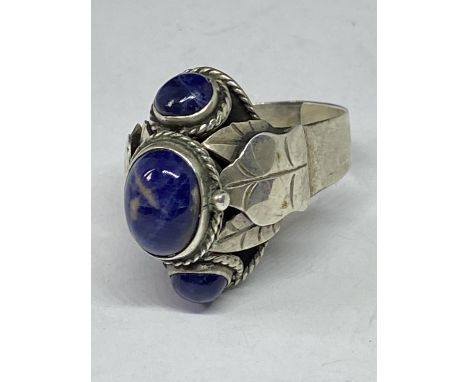 A LARGE SILVER RING WITH THREE BLUE STONES 