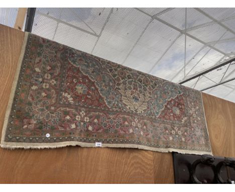A VINTAGE RED PATTERNED FRINGED RUG 
