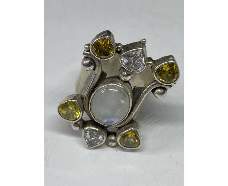 A LARGE SILVER RING WITH DECORATIVE COLOURED STONES 