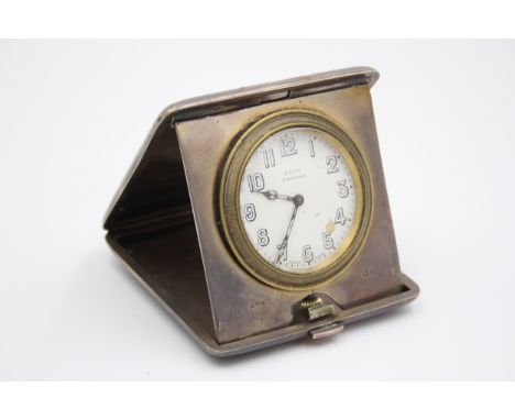 A silver cased travelling 8 day bedside clock, London 1920, with engine turned decoration, 9.5 x 9.5cm. 