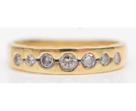 An 18K gold and seven graduated brilliant cut diamond ring, N, 3.3gm 