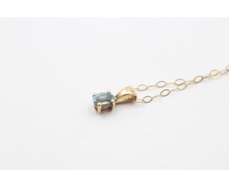A 9ct gold and blue topaz pendant, 10mm overall, chain, 0.7gm 