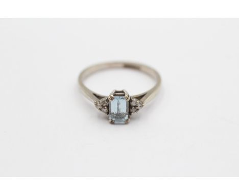 A 9ct white gold step cut aquamarine ring, with brilliant cut diamond trefoil set shoulders, M, 2gm 