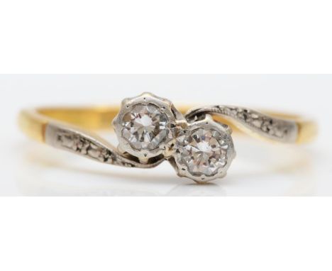 An 18ct gold two stone brilliant cut diamond set crossover ring, R, 2.7gm 