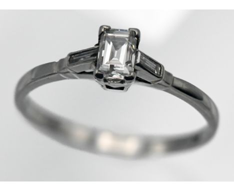 A platinum and diamond set single stone ring, set with an emerald cut diamond, size K.