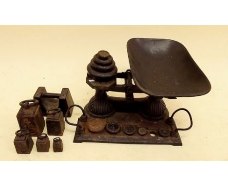 A set of antique kitchen scales and weights on integral stand and another set of cast iron weights