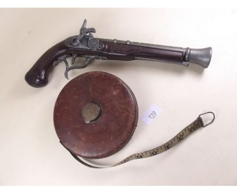 A replica gun and a vintage surveyors tape measure