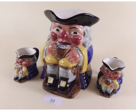 A large Clarice Cliff Newport pottery toby jug and two smaller ones
