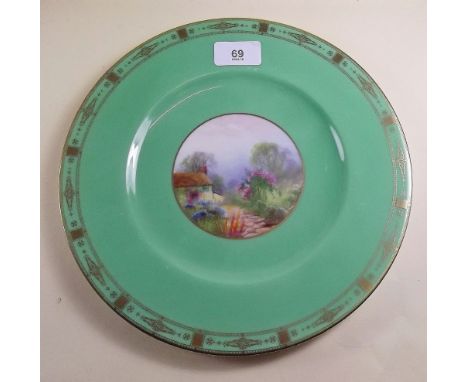 A Royal Worcester plate painted cottage and garden on a green ground, signed