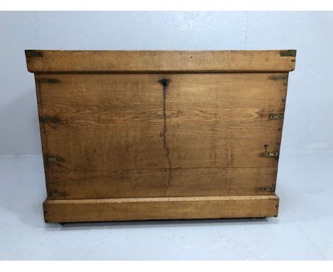 Antique furniture, light Oak plank box trunk on casters with brass reinforcing brackets to corners , approximately 84 x 54x 6