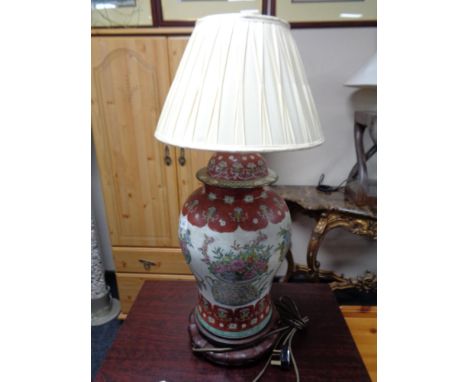 A Chinese table lamp on wooden stand 