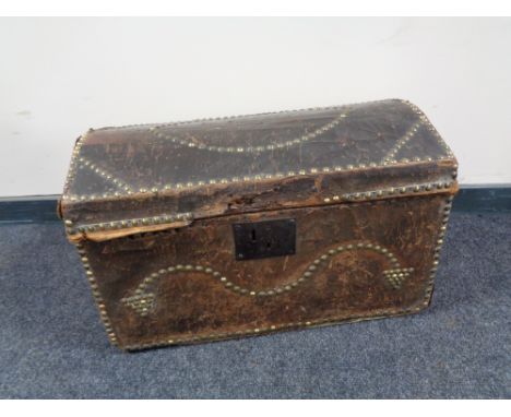A Georgian pine domed topped trunk in brass studded leather bearing initials J J CONDITION REPORT: Leather in very distressed