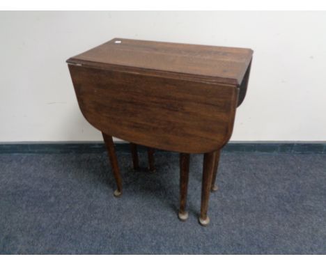 An oak gate leg table on club feet 