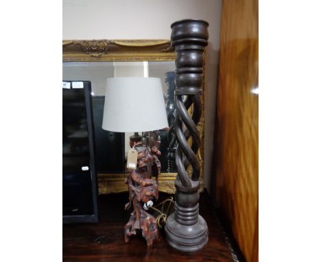 A carved hardwood table lamp with shade depicting a man, twist column plant stand 
