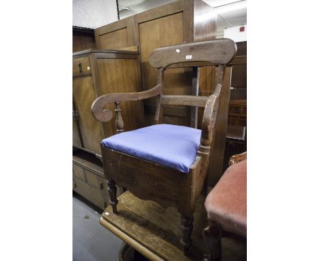 A DARK WOOD COMMODE CHAIR, SINGLE BACK RAIL SUPPORTS, SCROLL ARMS, PAD FEET ON TURNED FRONT SUPPORTS 